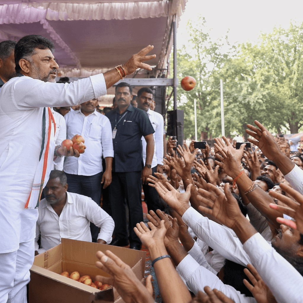 Karnataka CM D.K. Shivakumar throwing apples at supporters d · NewsDarpan AI