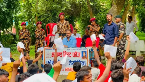 प्रतापगढ़ में अखंड हिंद फौज के बैनर के पीछे बैठे आयोजक और वर्दी पहने सदस्य, सामने फॉर्म लिए बैठे युवा