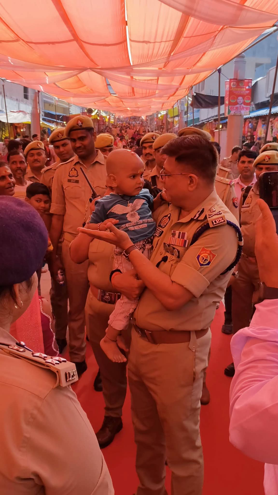 विंध्याचल धाम में श्रद्धालुओं से मुलाकात के दौरान बच्चे को गोद में लिए एडीजी नवीन अरोड़ा