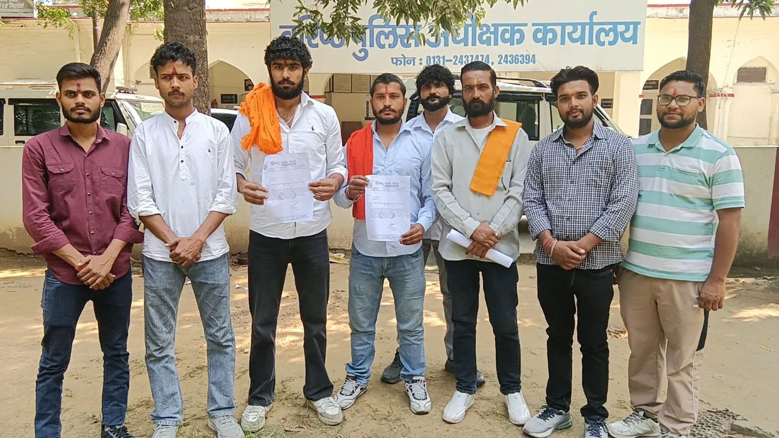 People holding documents outside an office in the photograph supplied with the Muzaffarnagar report.