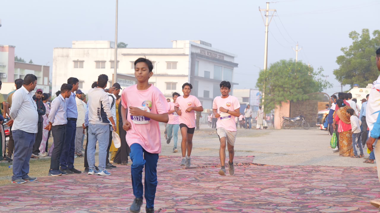 सतना हाफ मैराथन के दौरान गुलाबी टी-शर्ट पहने धावक दौड़ते हुए