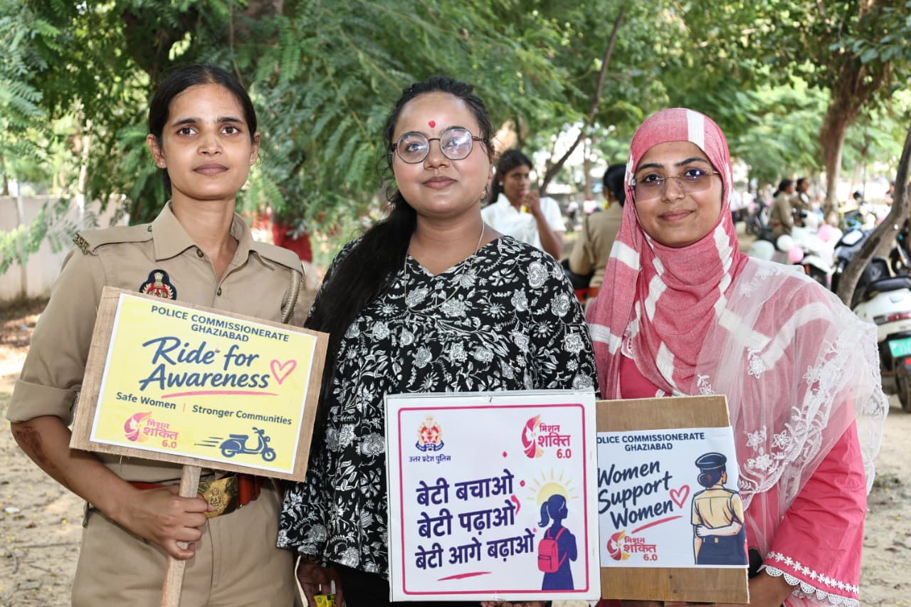 A policewoman and civilian women display awareness and women-support placards