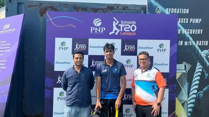 Cricketer with bat and helmet beside two people in front of a Schools T20 League backdrop