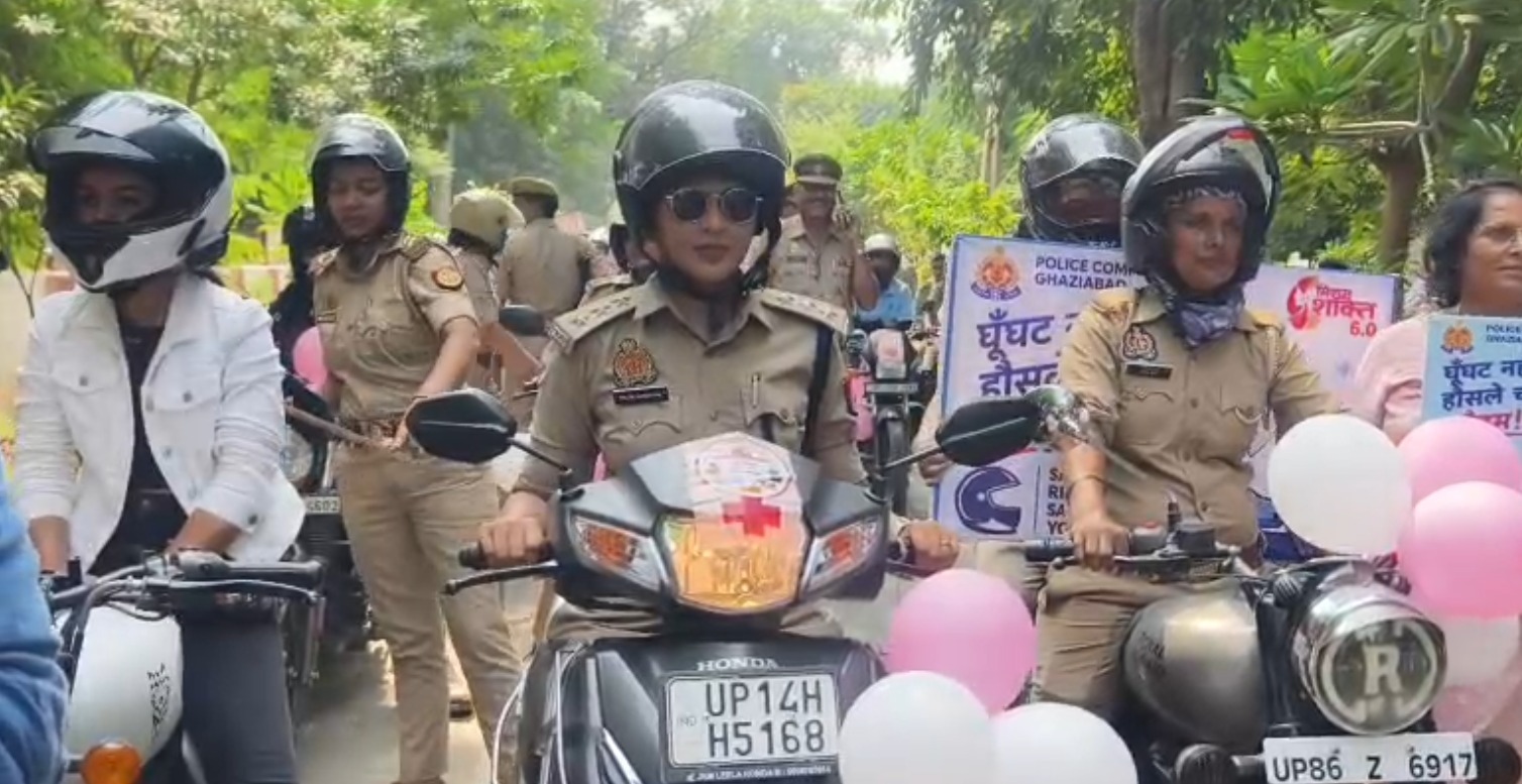 Helmeted women police officers and a civilian rider on two-wheelers at the Ghaziabad rally