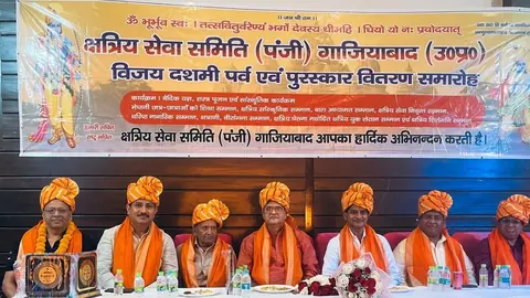 Guests wearing orange turbans seated on stage with awards at the Kshatriya Seva Samiti ceremony