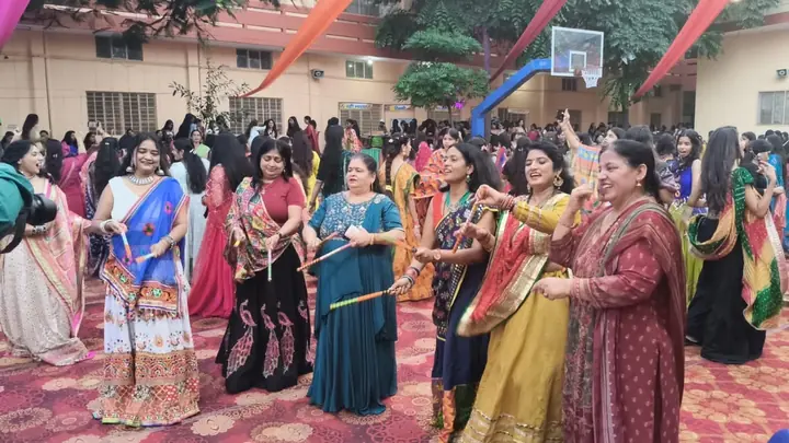 Participants in traditional clothing dance with sticks at the school cultural gathering