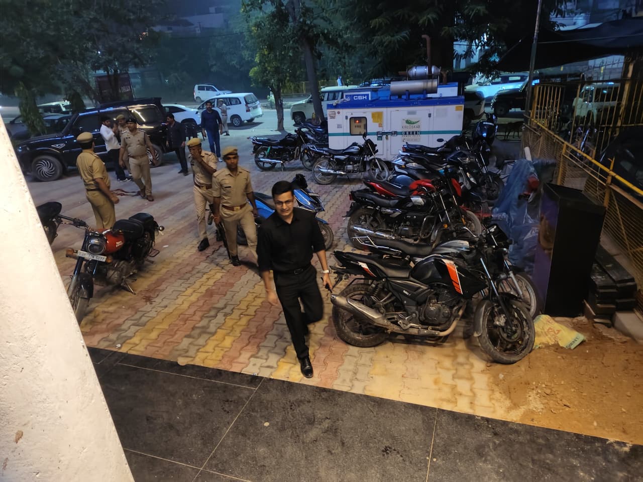 Police personnel and a man walking through a parking area