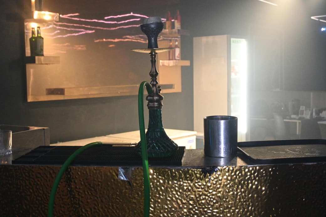 A hookah with a green glass base on a venue counter