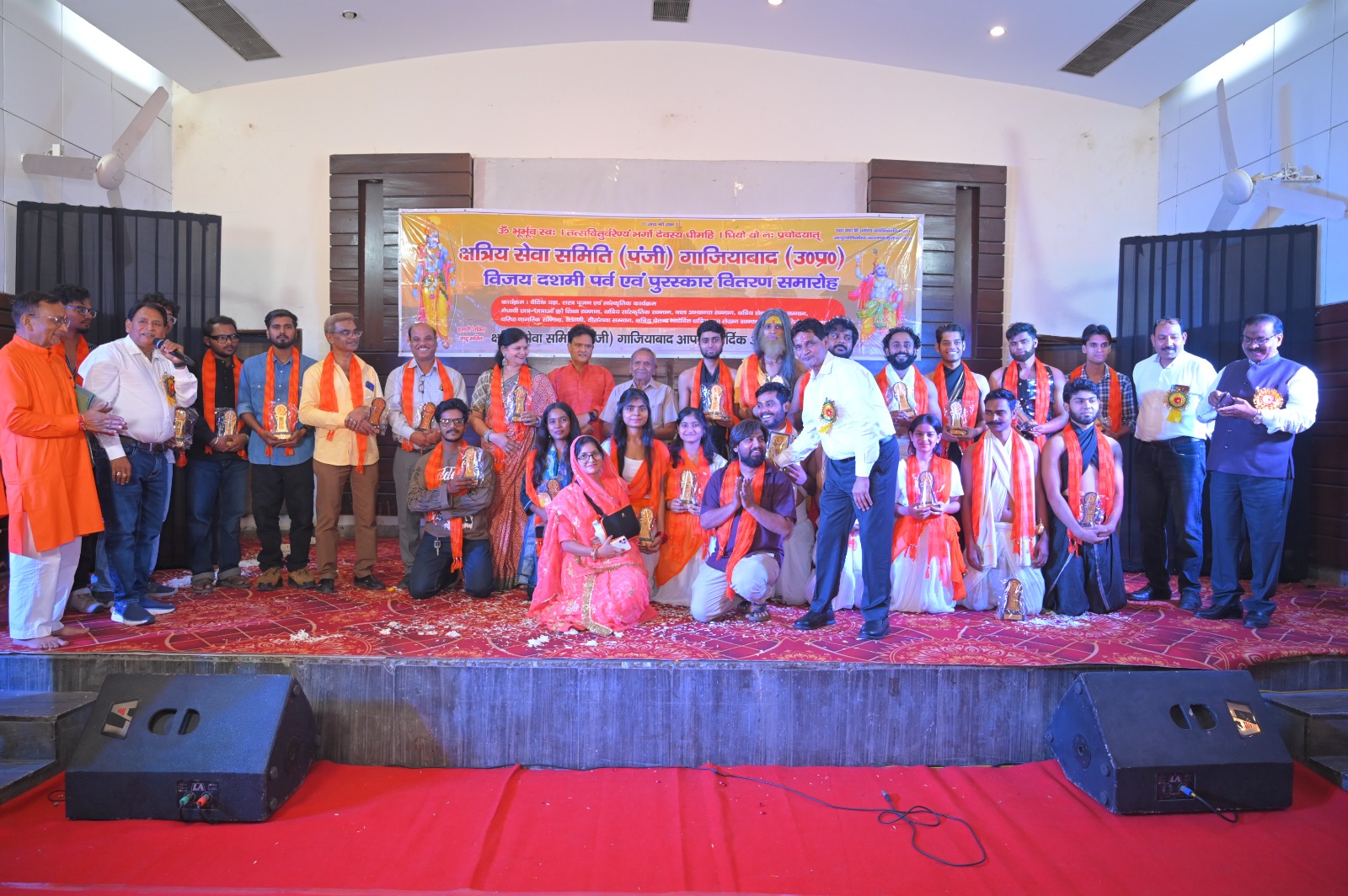 Group photograph on stage with awards at the Kshatriya Seva Samiti ceremony