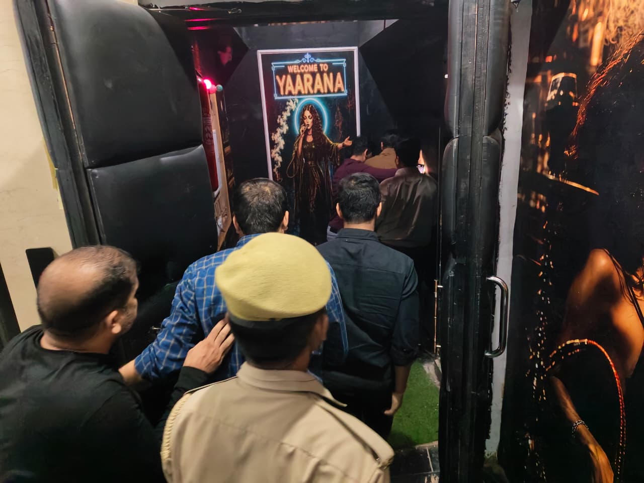 People and a uniformed officer entering a venue with a Welcome to Yaarana sign