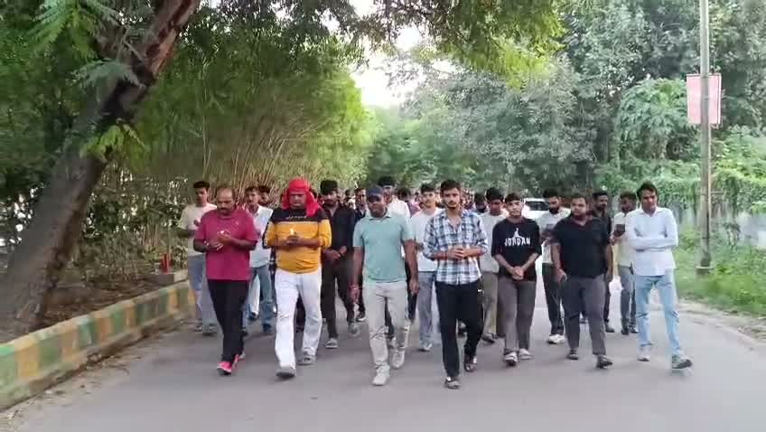 March participants walk together along a tree-lined road
