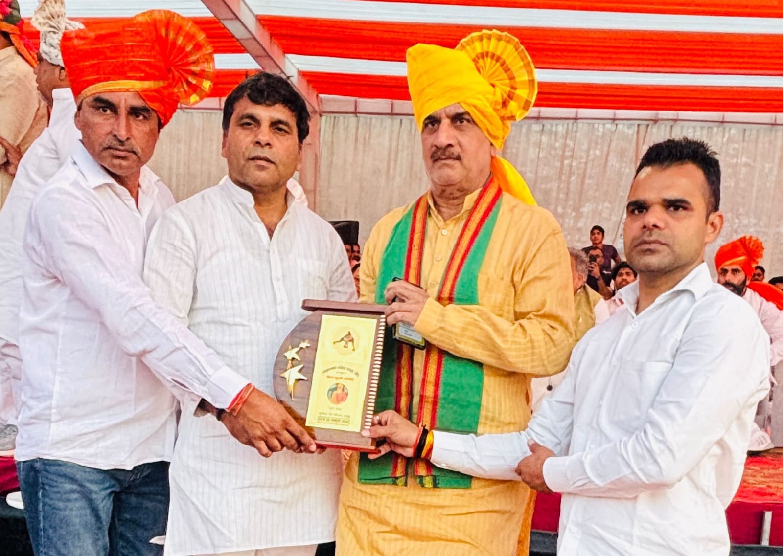Guests presenting an award plaque to a wrestler