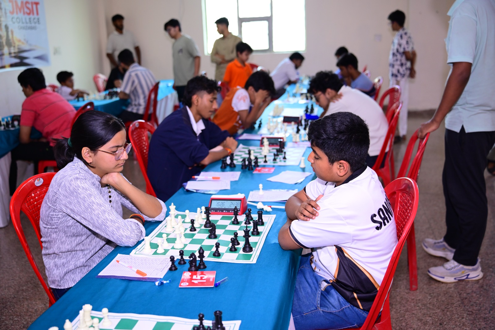 Participants play at tables during the chess competition.