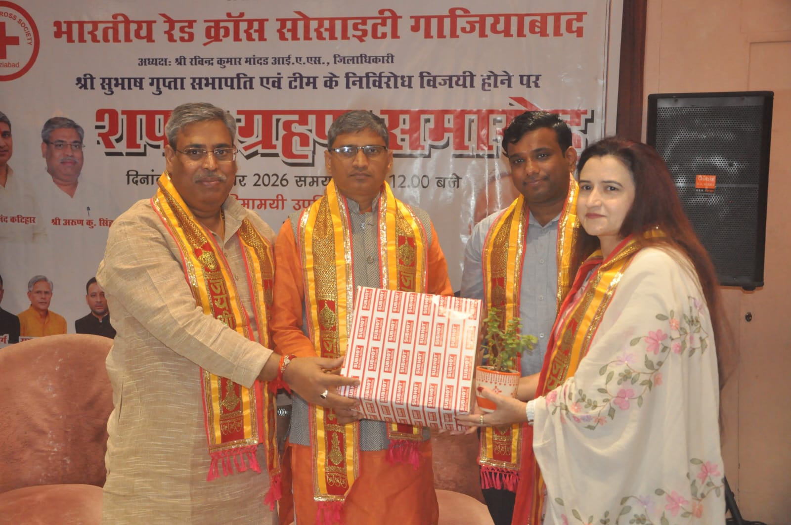 Participants with a gift and plant at the Red Cross ceremony.